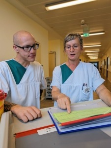 Zwei Personen schauen sich gemeinsam eine Patientenakte an.