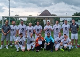 Die Fußballmannschaft der Stralsunder Werkstätten hält den Pokal als Sieger zum Landesmeister im Werkstättenfußball in Mecklenburg-Vorpommern in den Händen.