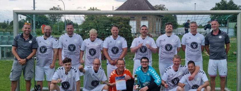 Die Fußballmannschaft der Stralsunder Werkstätten hält den Pokal als Sieger zum Landesmeister im Werkstättenfußball in Mecklenburg-Vorpommern in den Händen.