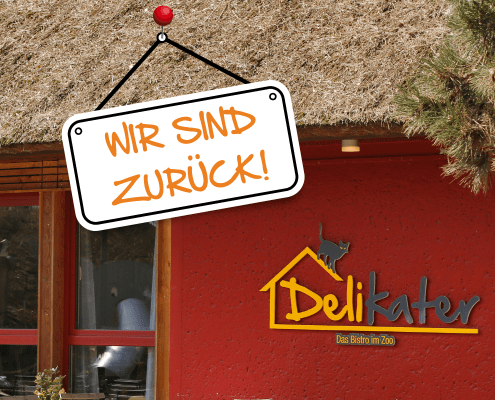 Im Hintergrund ist das Bistro Delikater zu sehen. Vorn hängt ein Schild mit der Aufschrift "Wir sind zurück".