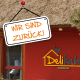 Im Hintergrund ist das Bistro Delikater zu sehen. Vorn hängt ein Schild mit der Aufschrift "Wir sind zurück".