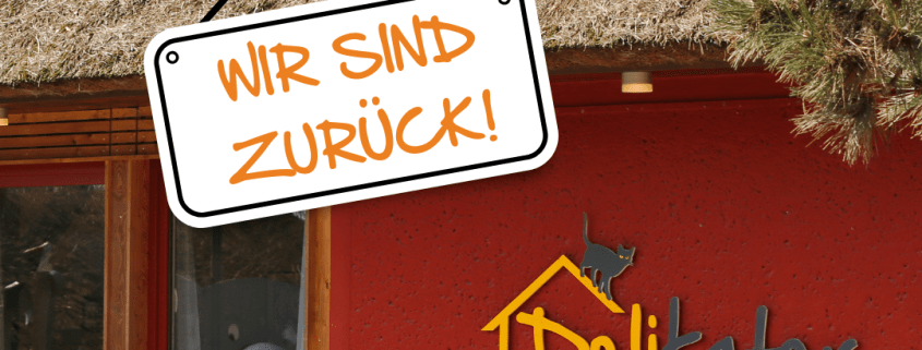 Im Hintergrund ist das Bistro Delikater zu sehen. Vorn hängt ein Schild mit der Aufschrift "Wir sind zurück".