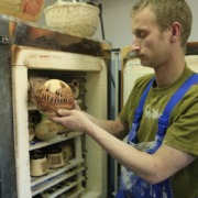Eine Person stellt ein Keramikprodukt in den Brennofen.