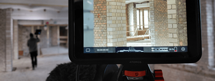 Das Foto zeigt den Blick auf den Bildschirm einer Filmkamera. Auf dem Bildschirm sind unverputzte Wände einer Baustelle zu sehen.