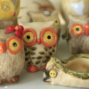 drei Keramikeulen mit großen gelb-orangenen Augen