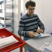 Eine Person verpackt Bücher in Briefumschläge.