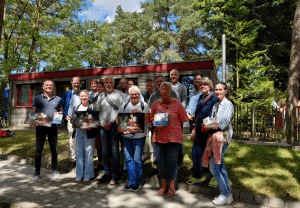 Ein Gruppenbild der Mitglieder des Projektes Netzwerk Inklusion Kreis Segeberg vor dem Bistro Delikater der Stralsunder Werkstätten.