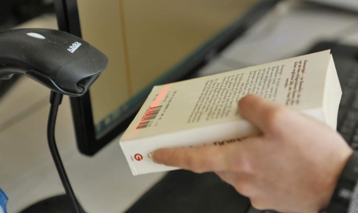 Eine Hand hält ein Buch unter den Scanner.