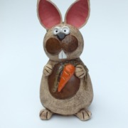 ein Hase aus Keramik mit einer Möhre in der Pfote