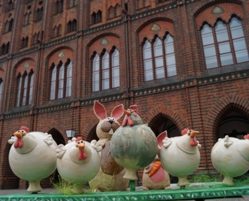 ein Hase und mehrere Hühner aus Keramik auf dem Alten Markt in Stralsund
