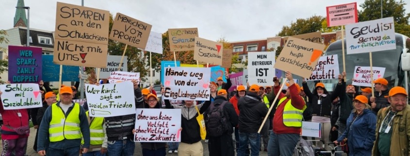 Menschen halten Plakate in die Luft.