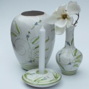 eine große und eine kleine Vase aus Keramik in weiß und grün, passend dazu ein Kerzenhalter