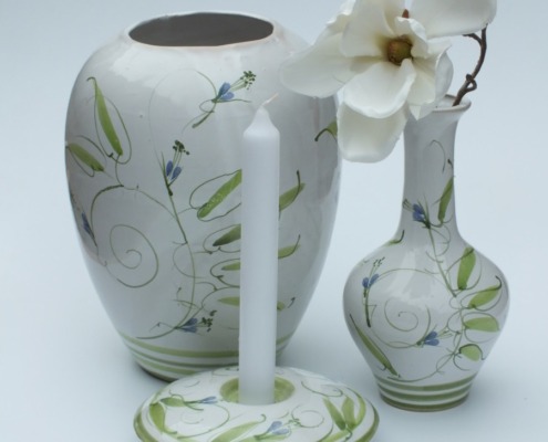 eine große und eine kleine Vase aus Keramik in weiß und grün, passend dazu ein Kerzenhalter