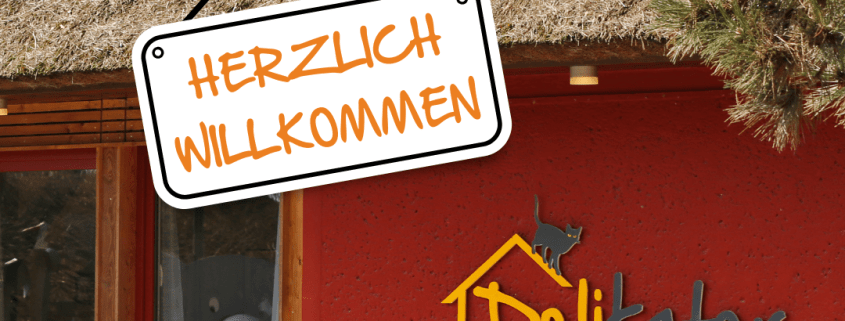 Vor dem Bistro Delikater hängt ein Schild mit der Aufschrift Herzlich Willkommen.