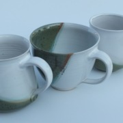 drei Tassen in unterschiedlichen Formen, alle sind teils weiß, teils olivgrün