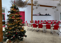 Im Speisesaal der Stralsunder Werkstätten steht ein geschmückter und beleuchteter Weihnachtsbaum.