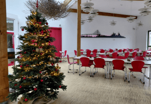 Im Speisesaal der Stralsunder Werkstätten steht ein geschmückter und beleuchteter Weihnachtsbaum.