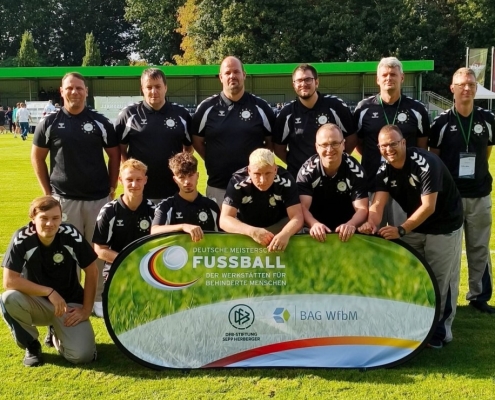 Zwölf Personen, die zur Fußballmannschaft der Stralsunder Werkstätten gehören, stehen auf einem Fußballplatz.