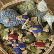 ein Korb mit vielen bunten Keramikfischen