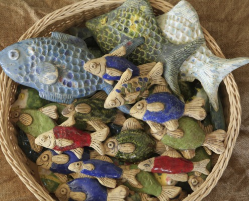 ein Korb mit vielen bunten Keramikfischen