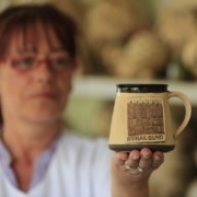 Eine Hand hält eine Tasse mit Stralsundmotiv